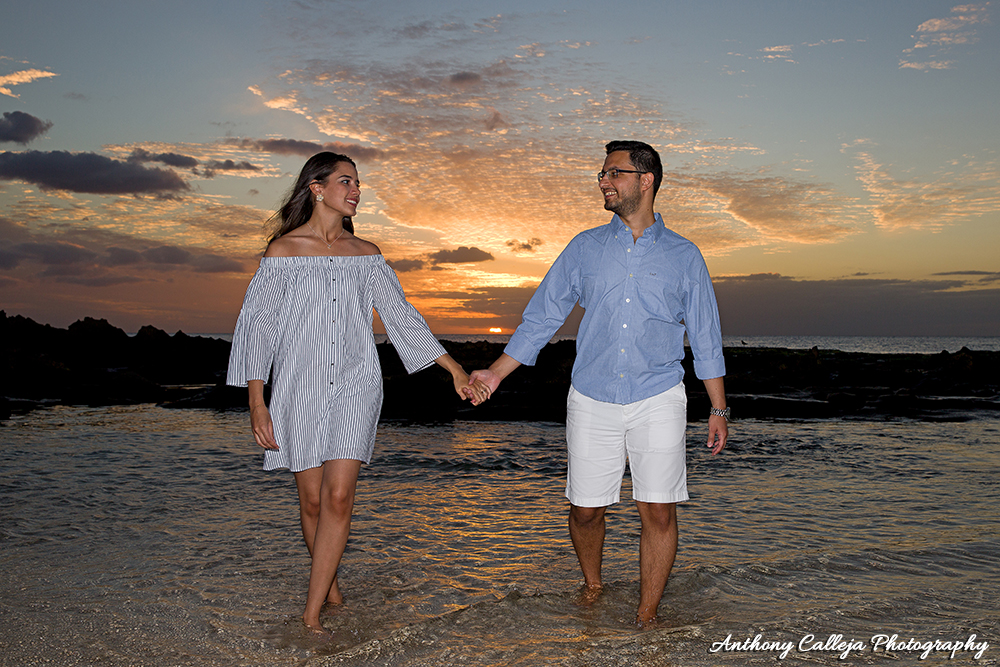Couple holding hands walking on the beach at sunset time wearing Blue and White